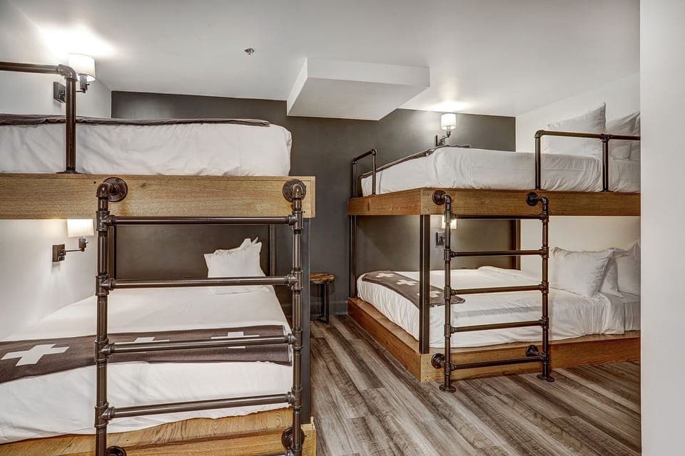 Modern bunk room with rustic-industrial design, offering a cozy and stylish retreat for group stays.