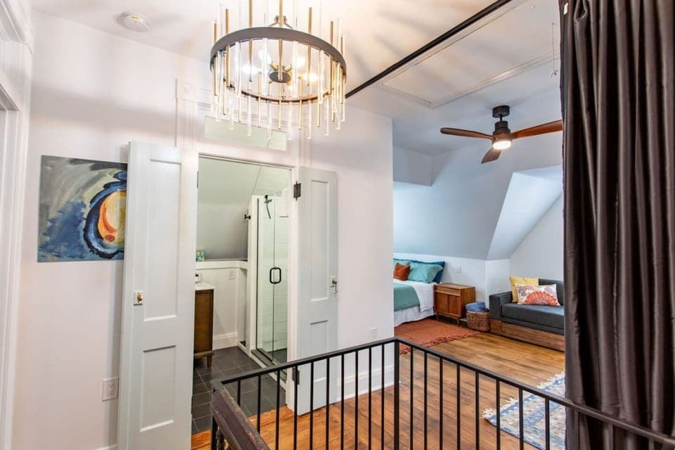 A stunning view that showcases the living area, bathroom, and bedroom, all highlighted by an elegant, classy chandelier that adds a touch of luxury and sophistication to the space.