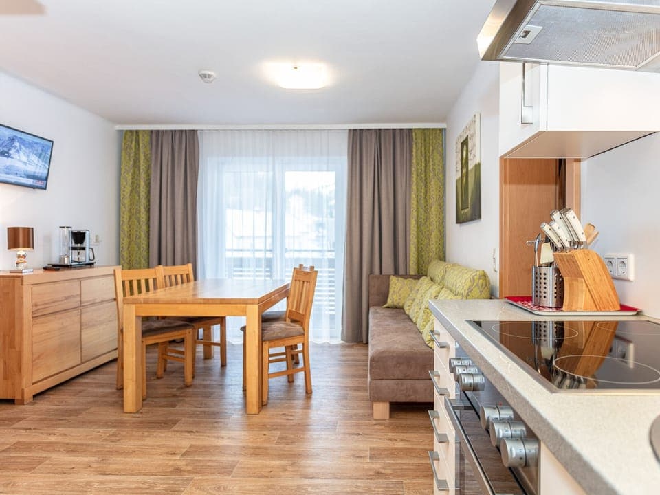 Dining room in Appartements Hollin by we rent apartments in Saalbach, with a table, and chairs. Mountain view.