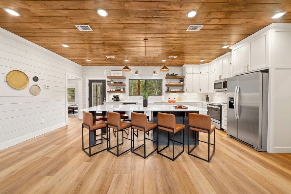 This inviting kitchen features a spacious Quartz countertop, oversized barstools surrounding an oversized island with plenty of room for storage!