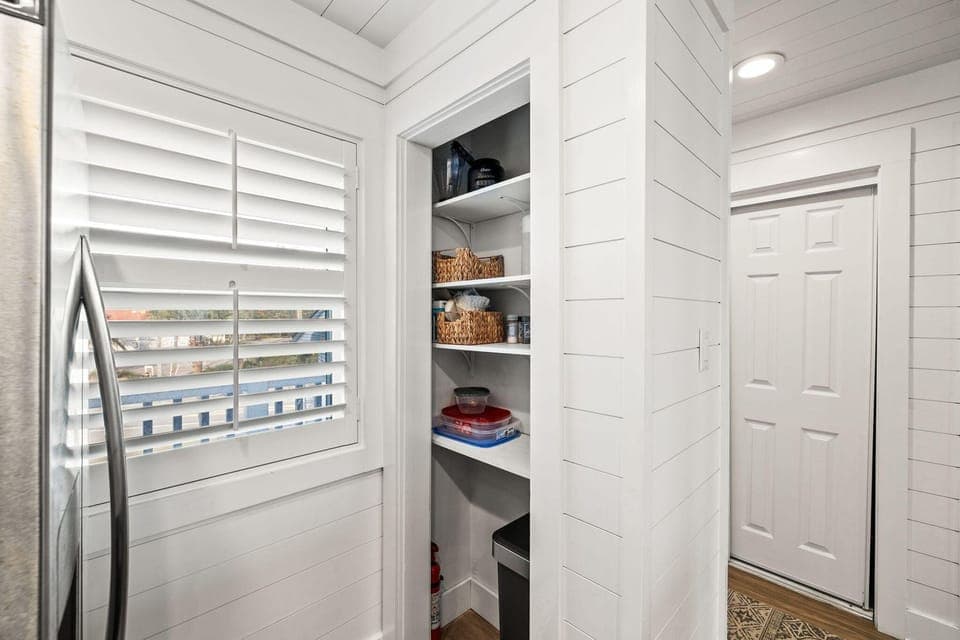 Your well-organized pantry keeps everything within easy reach, featuring built-in shelving and charming shiplap details that blend style with functionality.