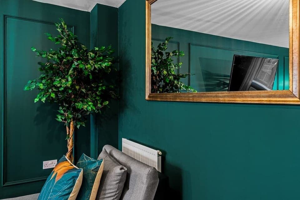 A refined blend of elegance and comfort, this living room features high ceilings, statement lighting, and plush seating bathed in natural light. Premium fabrics, rich wood accents, and exquisite décor create an inviting atmosphere for relaxation.