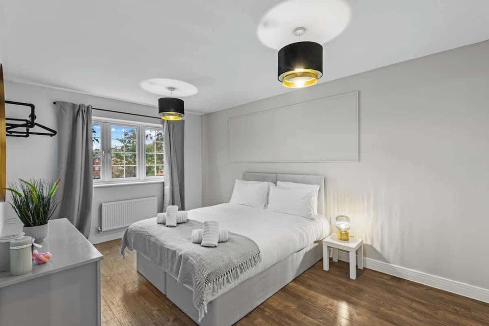 This bedroom embodies a fresh, minimalist aesthetic with a focus on simplicity and tranquility. Crisp white linens, sleek furniture, and a neutral color palette create a bright and airy atmosphere.