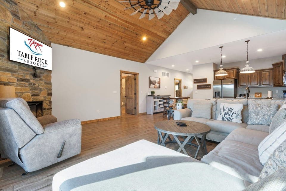 This spacious home features an open floor plan with a fantastic living area, a large sectional sofa, cable TV, a seasonal fireplace, and deck access.