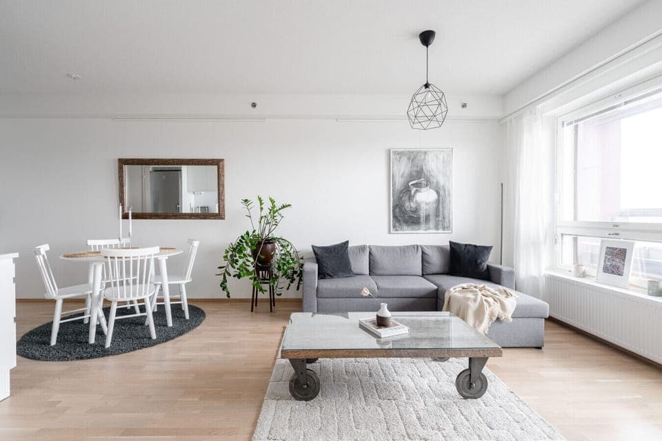 The spacious living area features a comfortable sofa and a stylish industrial-style coffee table, perfect for relaxing after a day of sightseeing.