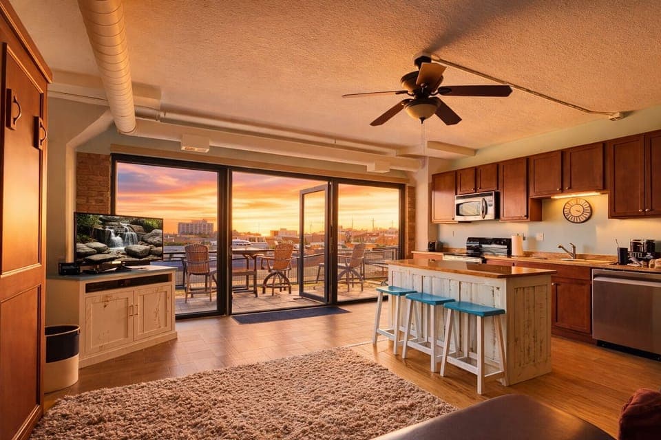 This bright and airy loft invites you to unwind with an open-concept layout, rustic coastal decor, and large sliding doors leading to a breathtaking waterfront patio. The fully equipped kitchen and spacious seating make it feel like home.