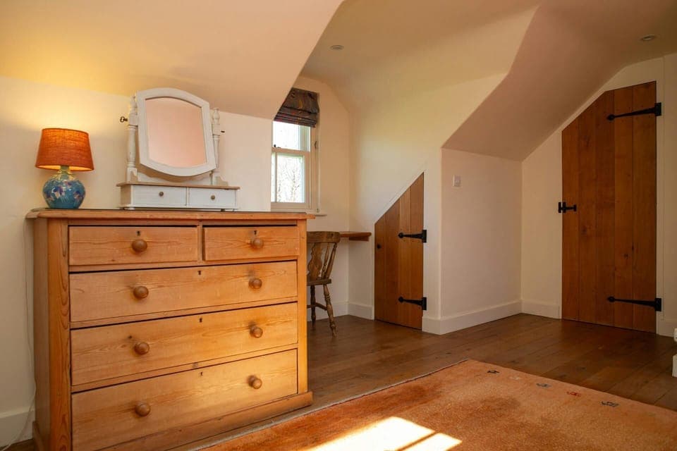 Double bedroom with a chest of drawers with a lamp and mirror