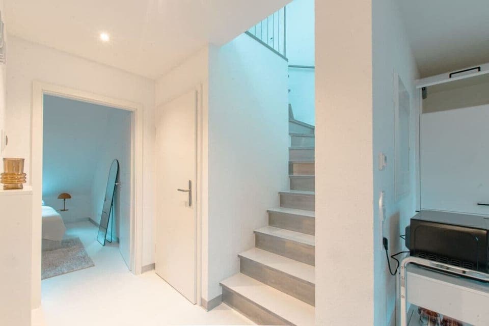 Ein Blick aus dem offene Wohn-und Essbereich in den Flur und das Schlafzimmer, sowie die Treppe in den oberen Bereich der Wohnung.