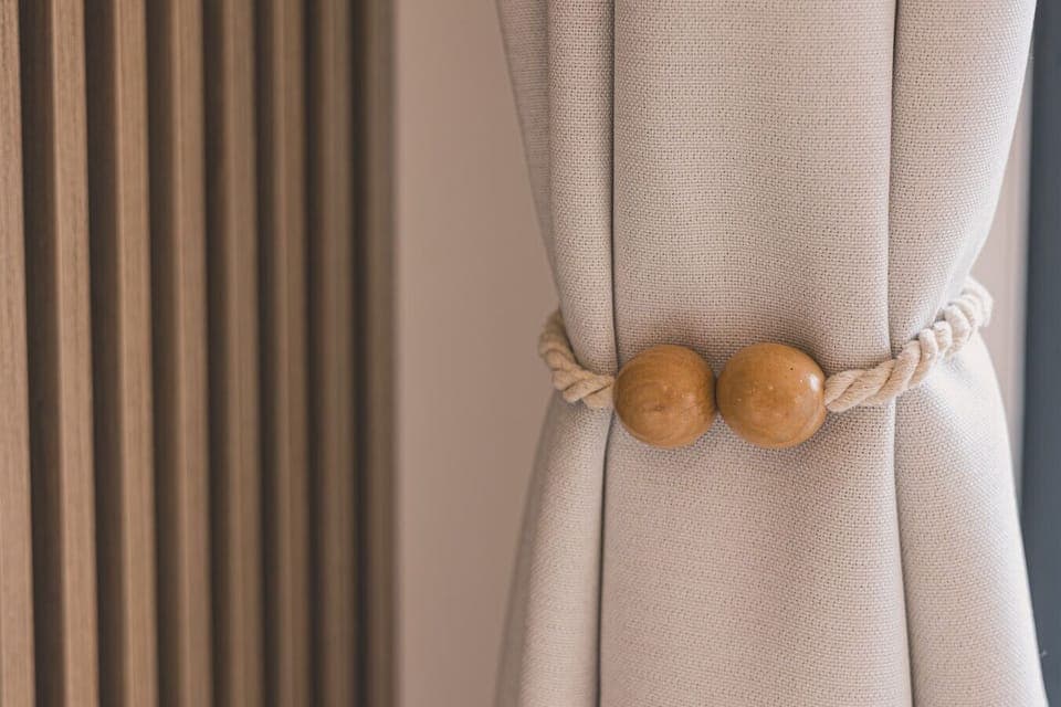 Stylishly tied curtains in warm amber tones add elegance and a cozy glow to the space.