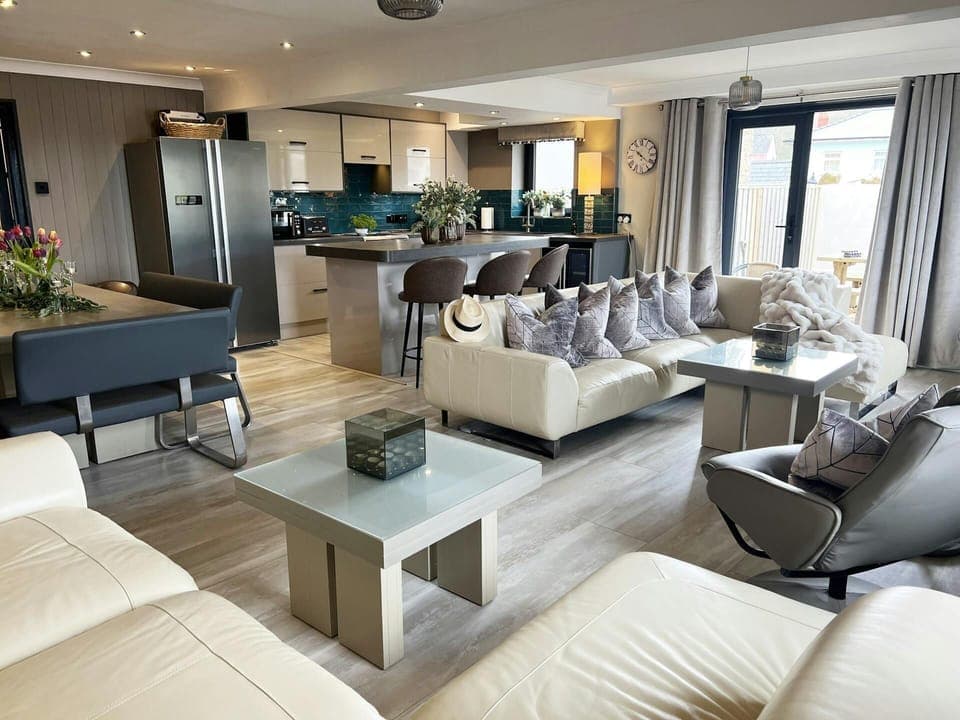 Graftons living room, sofas, coffee table, patio doors, kitchen and dining areas