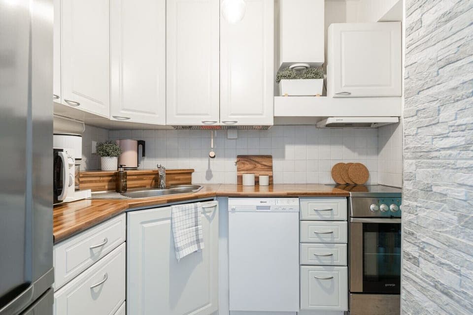 The compact kitchen is fully equipped with modern appliances, including a dishwasher and a microwave for your daily needs.