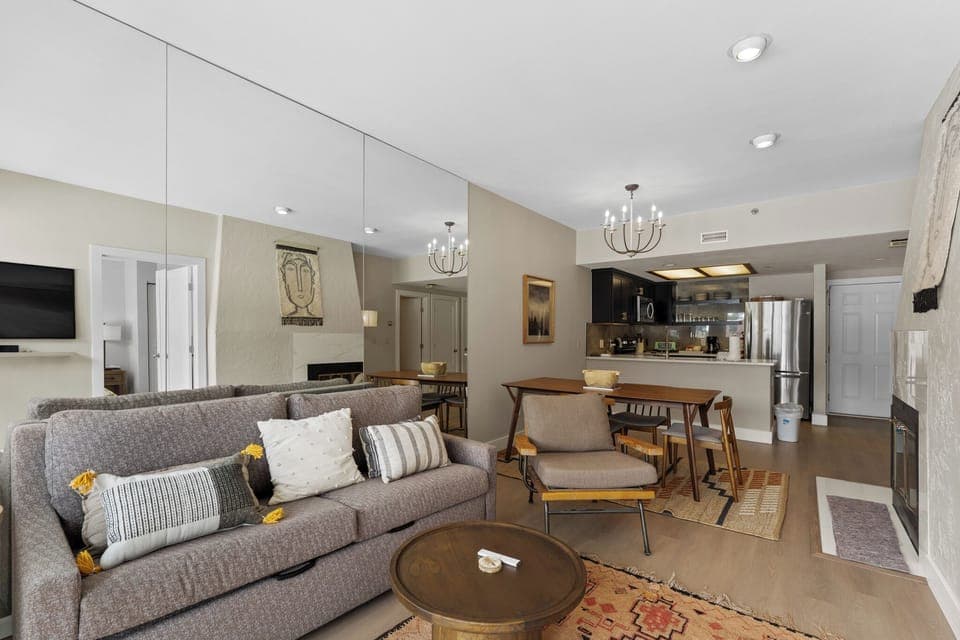 Living area featuring a flat-screen TV, queen sleeper sofa, and access to the private balcony.