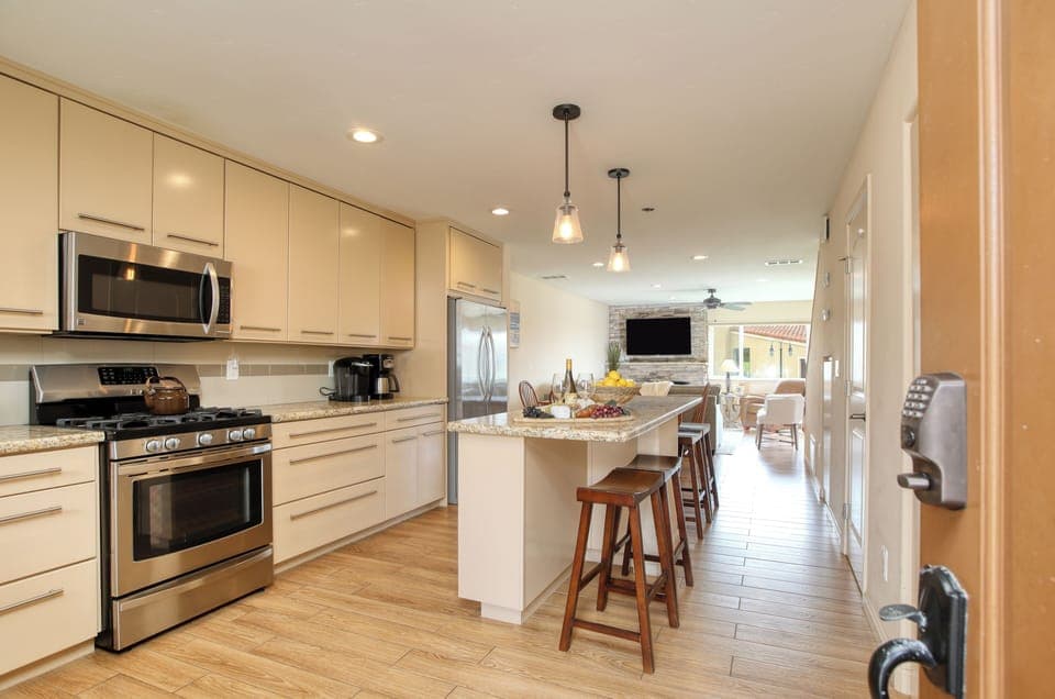 The chef’s kitchen features high-end appliances, a long prep island with bar seating, and dining for six, perfect for entertaining or family meals.