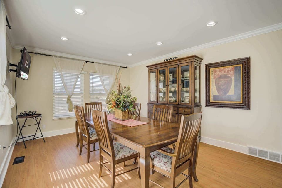 Elegant dining room with a spacious table, a beautiful china cabinet, and plenty of natural light for a warm and inviting atmosphere.




