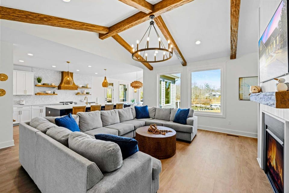 Unwind in this stunning lakefront retreat! Cozy up by the fireplace, relax on the plush sectional, and enjoy breathtaking views. With vaulted ceilings, wood beams, and designer touches, this open-concept space is perfect for making unforgettable memo