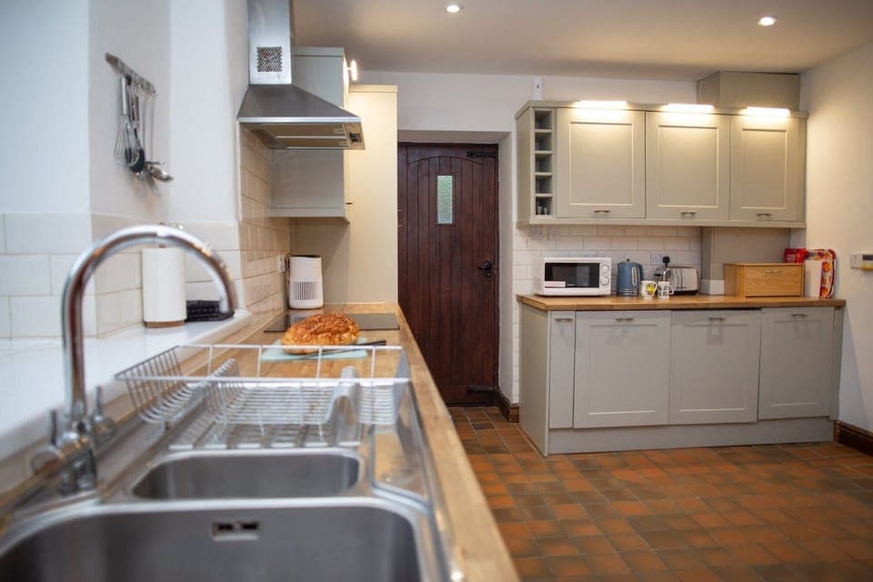 Modern kitchen with sink and drainer in foreground and grey cabinets in background