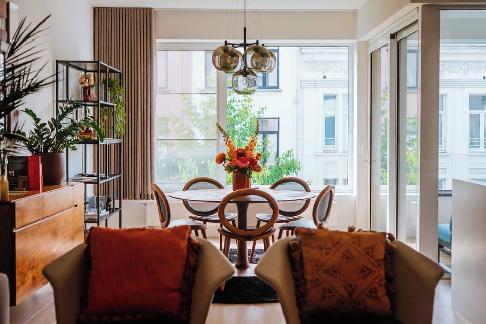 Bright living and dining area in a stylish holiday apartment in Antwerp Zuid. Modern design, natural light and city views.