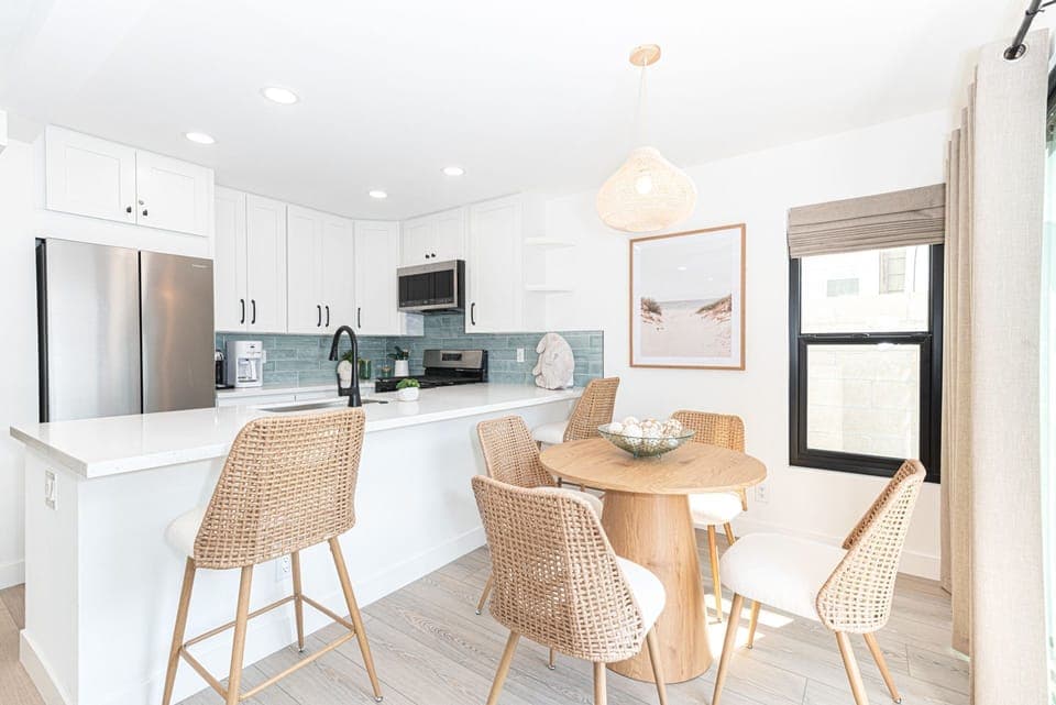 Gather in the airy, open-concept dining area featuring sleek finishes and bar seating, perfect for casual meals
                