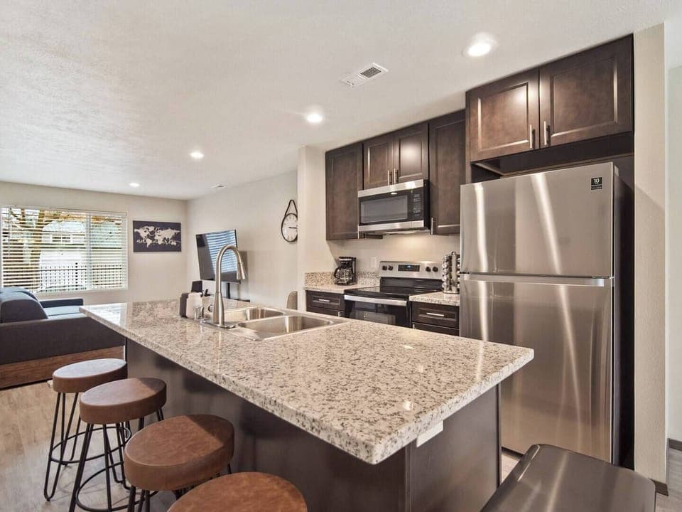 Full kitchen with sink in-island and bar seating. 