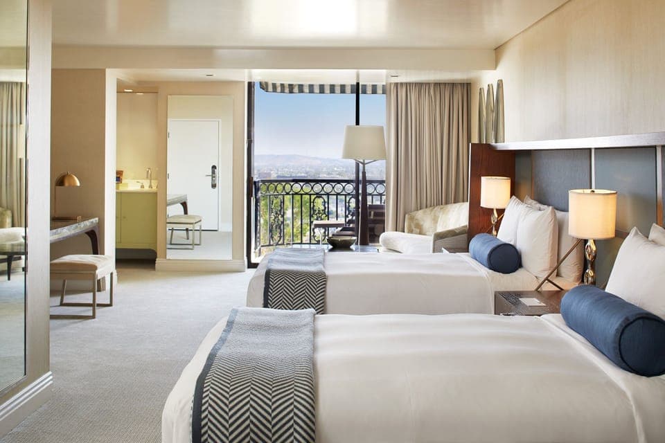 Stretch out in double beds with a balcony view beyond.