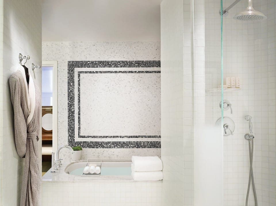 Rinse off under the rain shower in a serene tiled retreat.