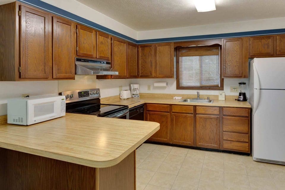 Fully equipped kitchen with ample counter space, microwave, coffee maker, and dishwasher.