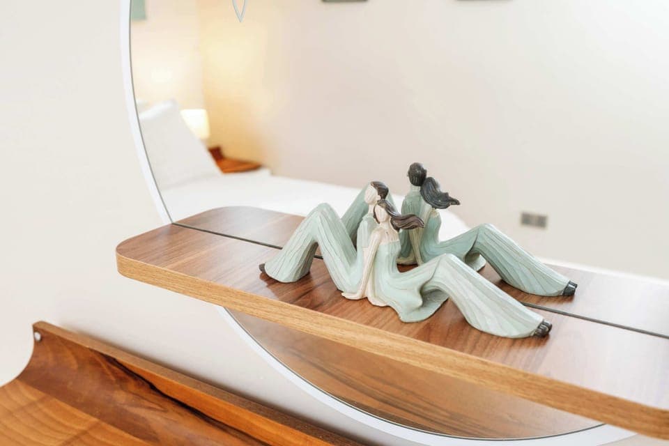 The elegant couple figurine and chic mirror add a touch of charm and style to your primary bedroom, creating a warm ambience.