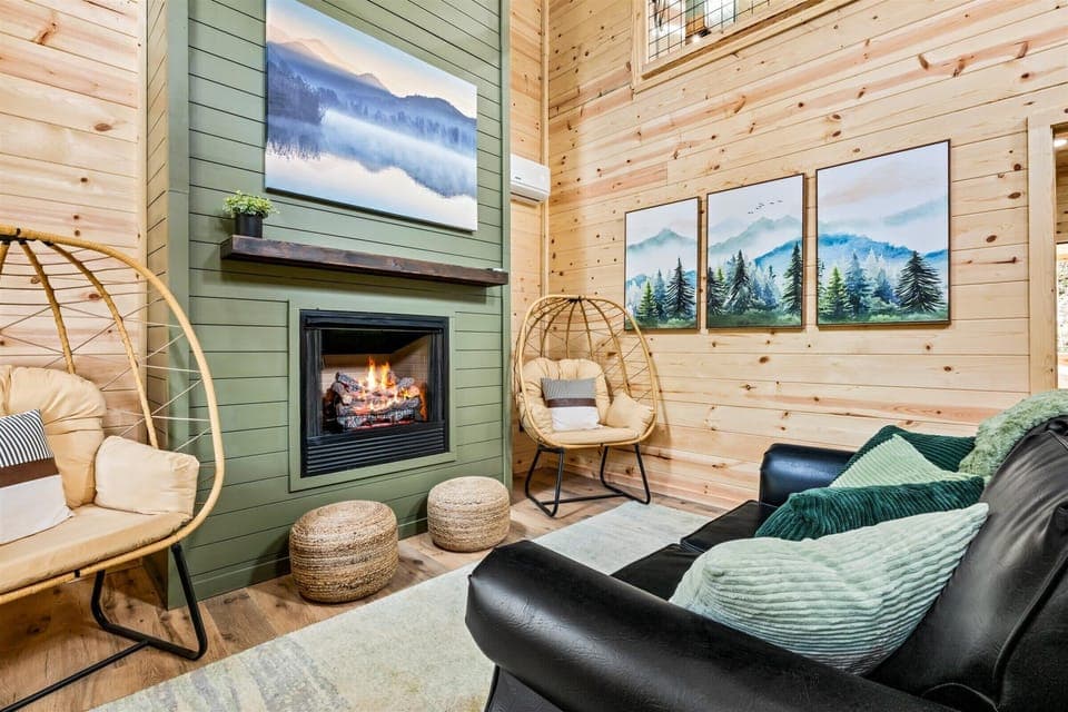 Cozy living room featuring green & wood tones w/a warm fireplace centerpiece.
