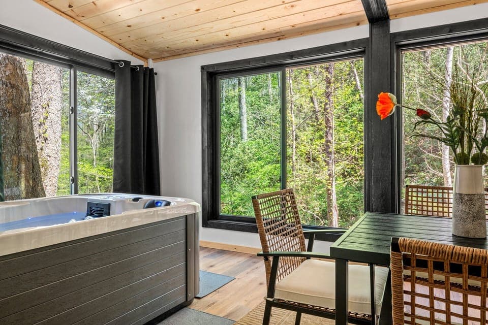 Soak and unwind in the hot tub surrounded by serene nature views.