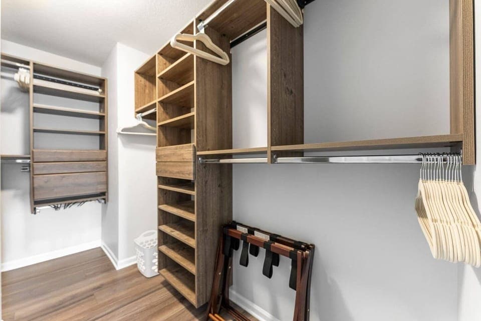Spacious walk-in closet with custom wood shelving and hanging rods