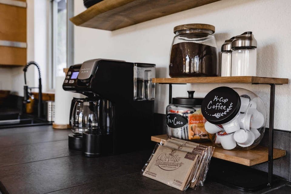 Coffee bar set up with ground coffee, k cups, sugar, power creamer, tea, coco and microwave popcorn for movie night.