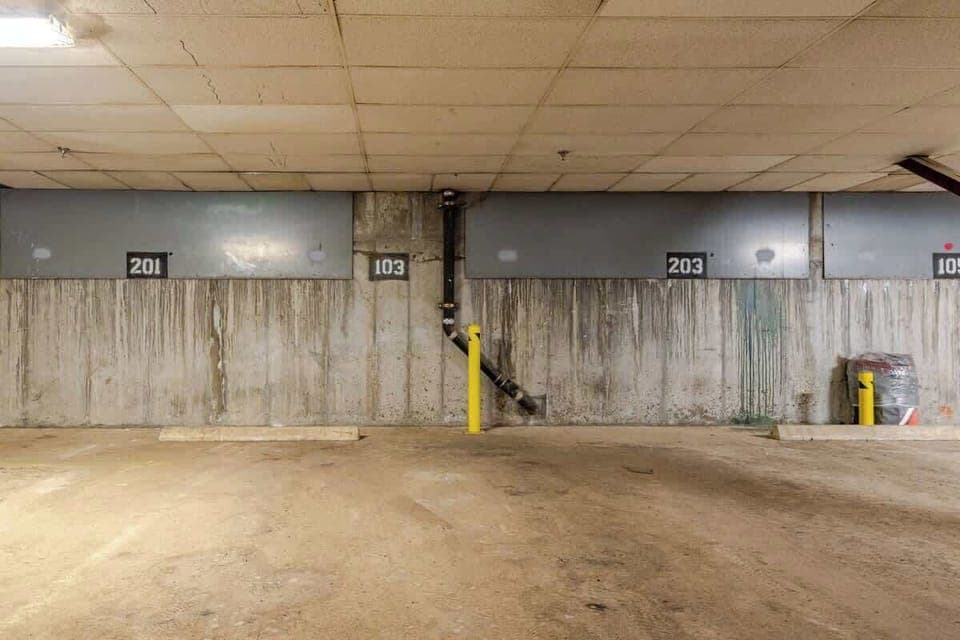 Indoor parking with clearly numbered spots, concrete walls, and easy access—ideal for secure, short-term vehicle storage.