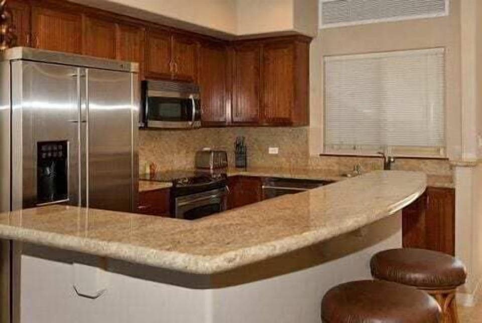 Cook with ease in this modern kitchen featuring stainless steel appliances and a spacious breakfast bar.