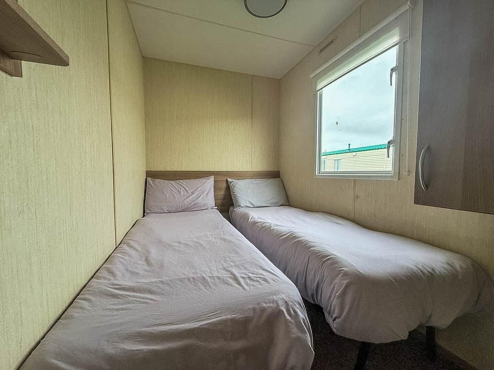 Cozy twin bedroom with natural light and storage space