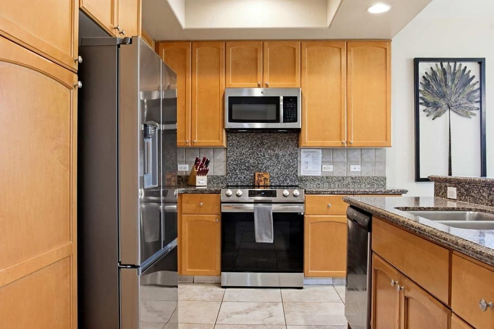 Modern kitchen with stainless steel appliances and granite countertops.