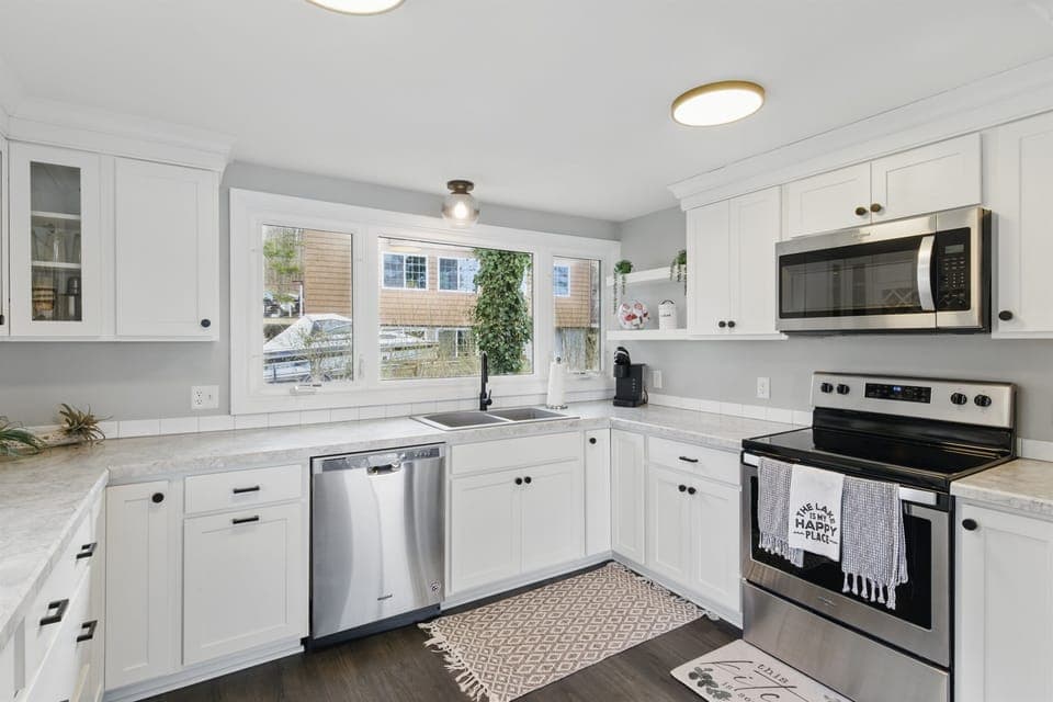 Modern lakeview kitchen featuring stainless steel appliances, white shaker cabinets, and sleek countertops – perfect for home-cooked meals with a view.