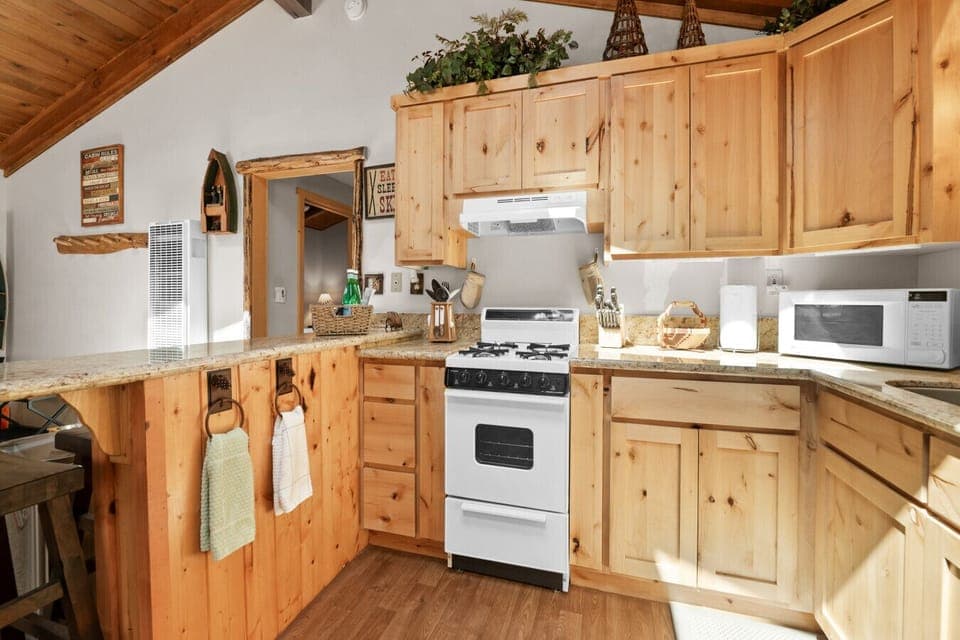 Fully equipped kitchen w/ natural wood cabinetry & everything needed for easy meals.