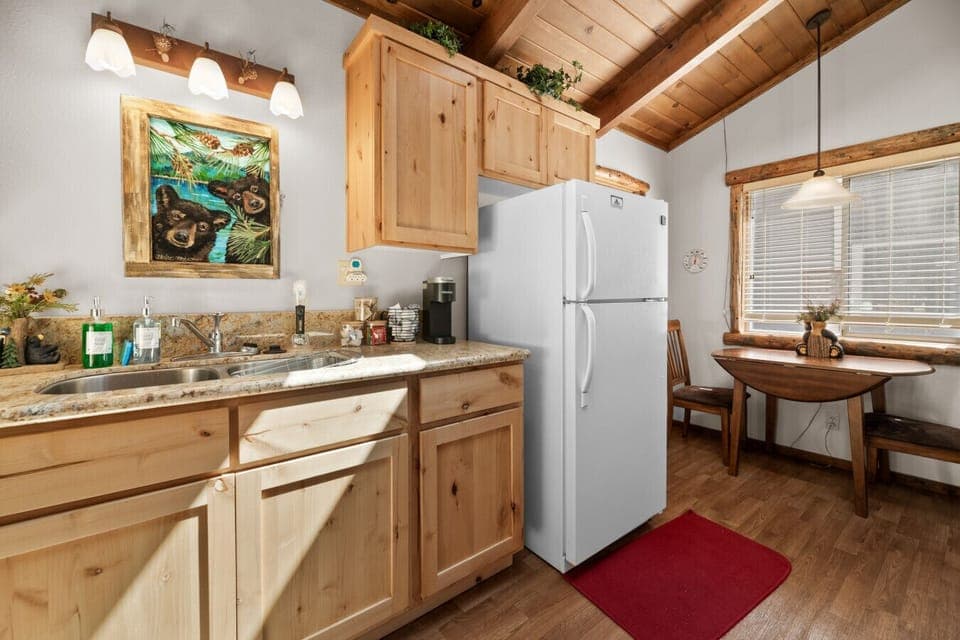 Sunlit kitchen workspace w/ wood cabinetry, ample counters & everyday essentials.