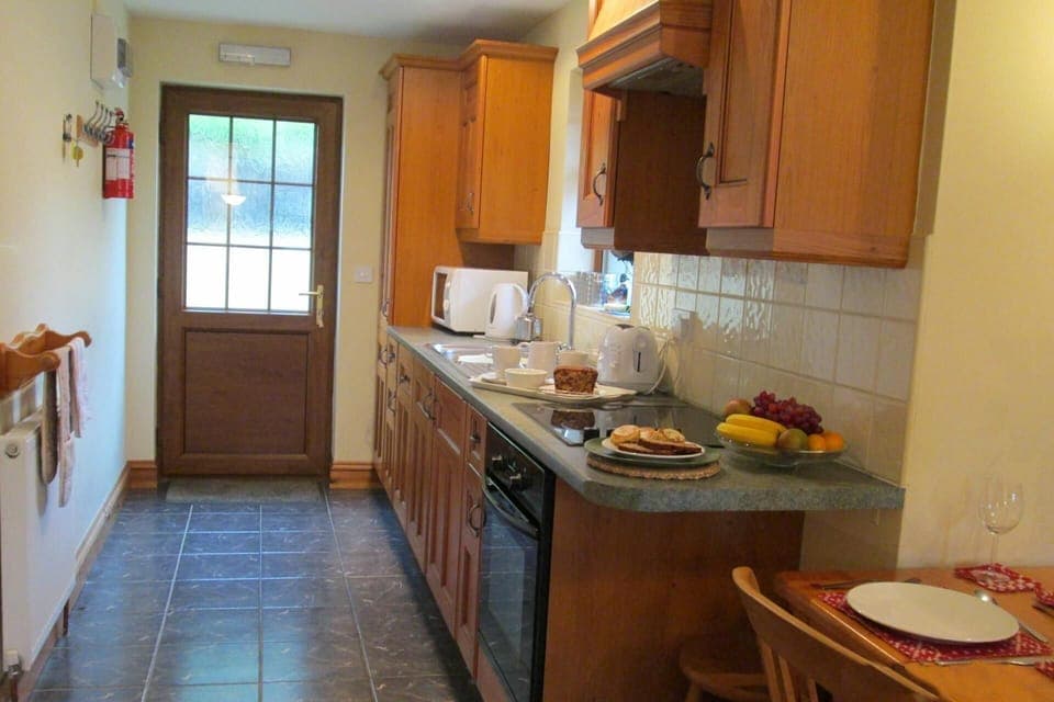Kitchen with wood units, oven and microwave