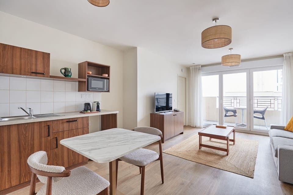 Open-plan layout with fully equipped kitchenette, dining area, and comfortable sofa—ideal for short or extended stays.