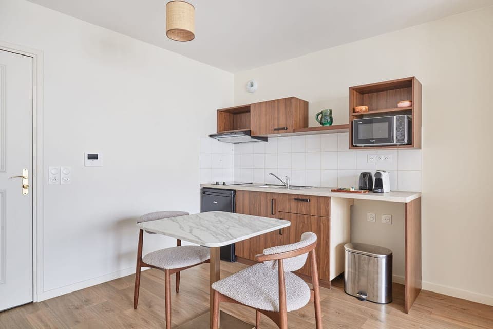 Modern kitchenette featuring induction hobs, microwave, fridge, kettle, coffee maker, and extractor—everything you need for a comfortable stay.