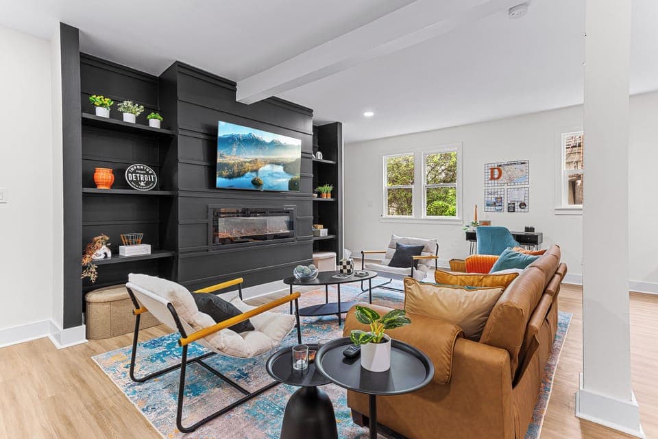 Stunning living space with 65'' TV, electric fireplace, pillows, throws