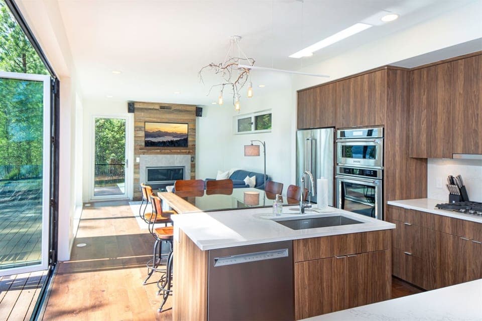 The open concept kitchen, dining & living room is framed by accordion style doors that bring the outdoors within | Main Floor