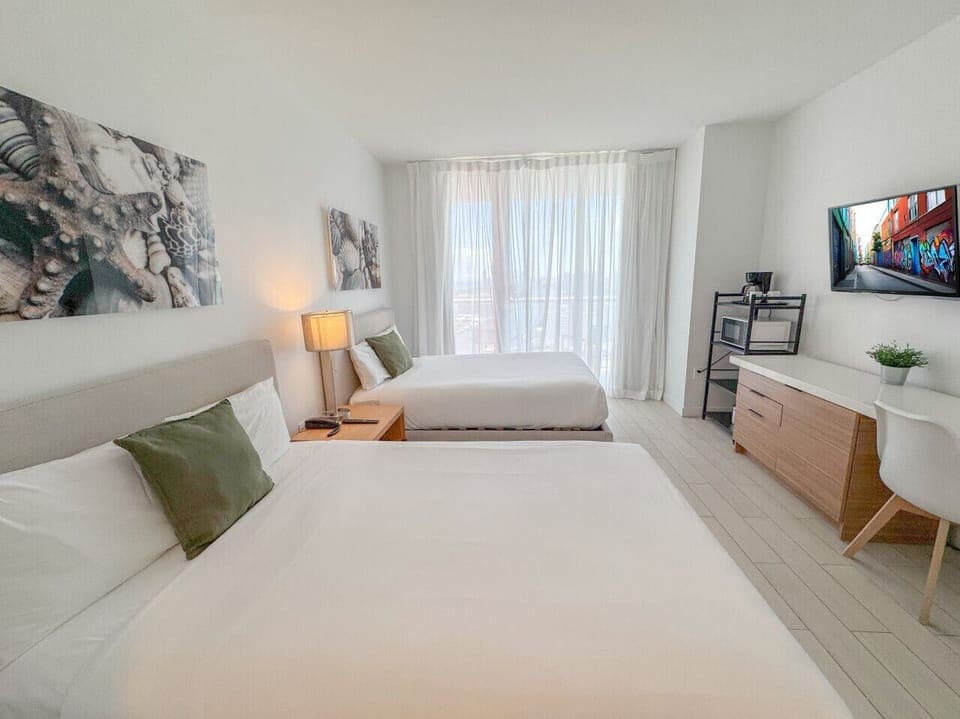 Bright room with two comfortable beds and outdoor views.