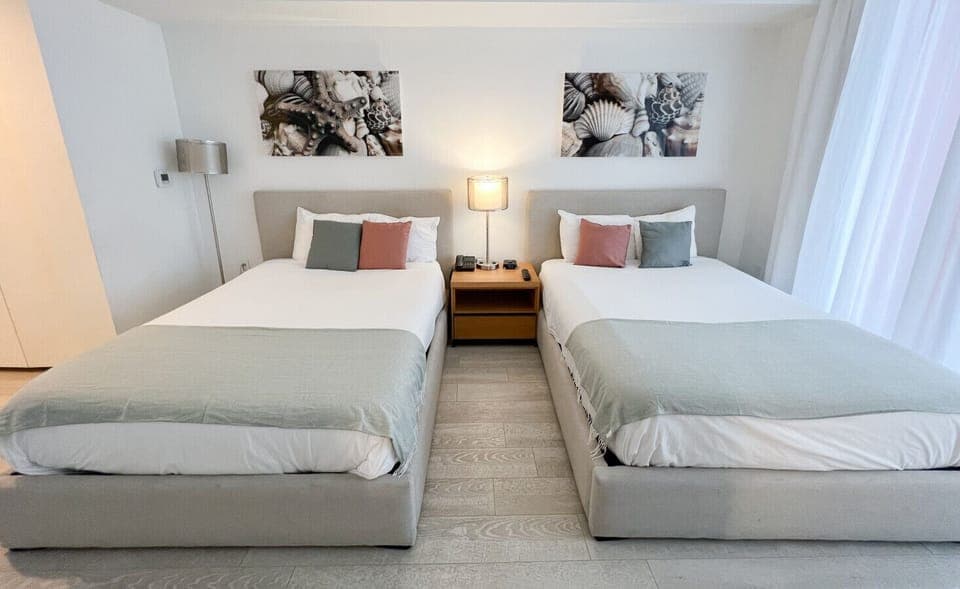 Bright and spacious bedroom with two double beds and natural light.