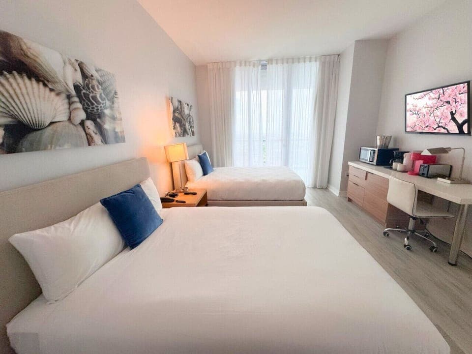 Spacious bedroom with balcony access and Smart TV.