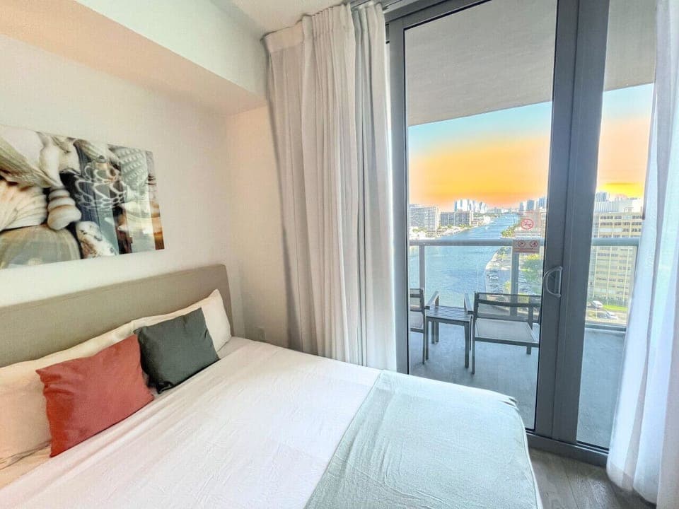 Spacious bedroom with a  bed, flat-screen TV, and bright natural lighting.