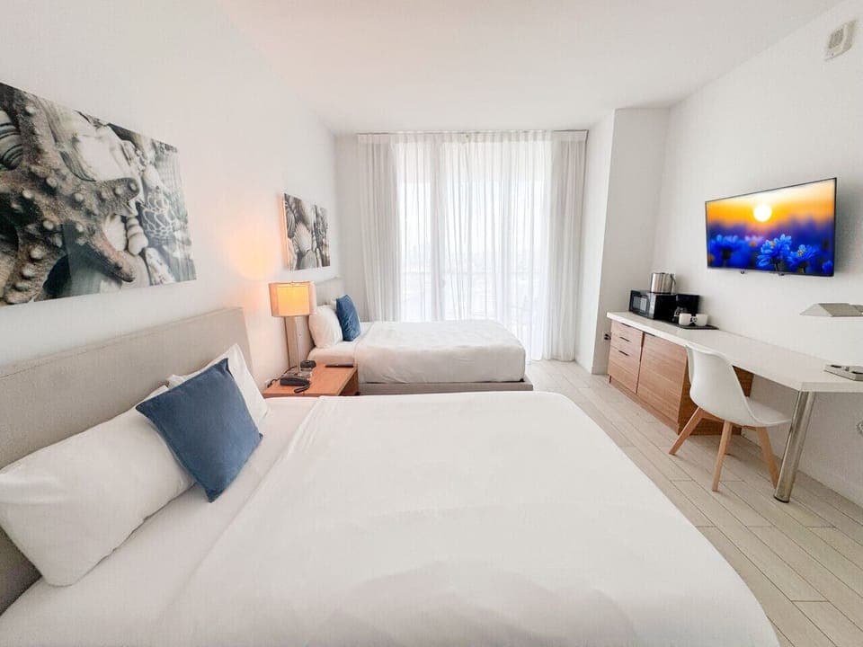 Spacious bedroom with balcony access and Smart TV.