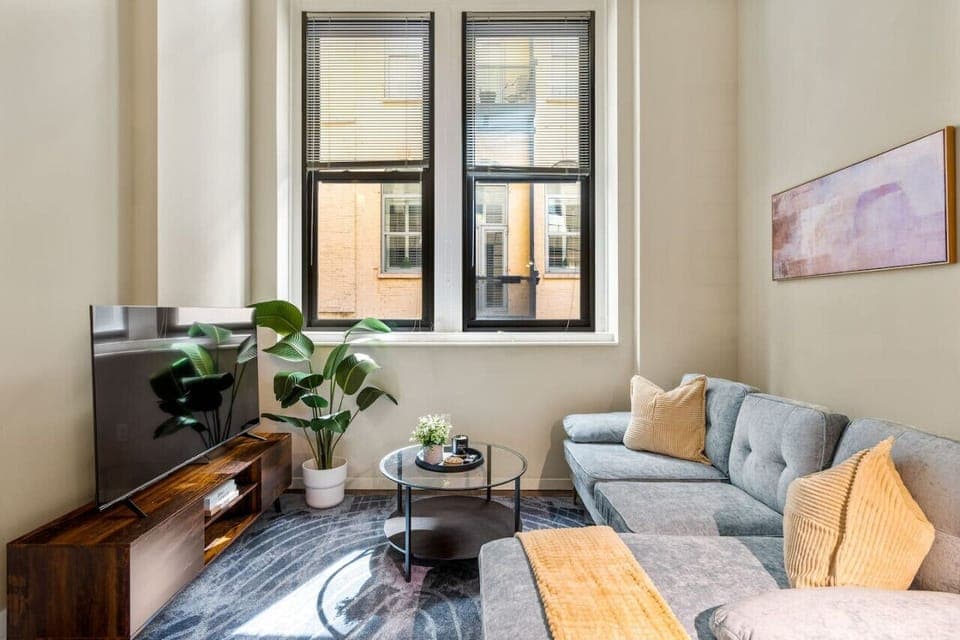 The living room’s plush seating beckons you to sink in and relax, surrounded by light and airy decor.