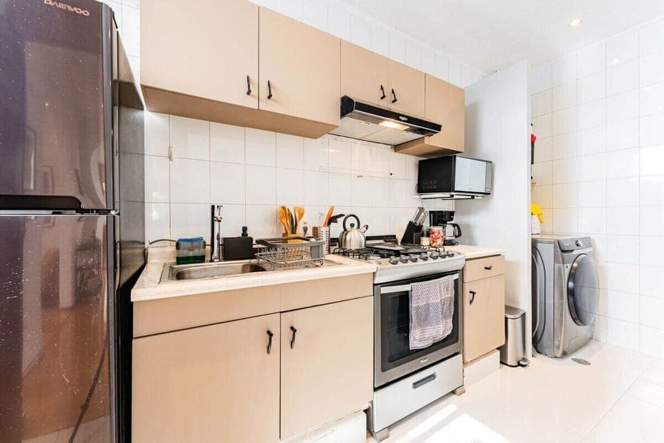 Fully equipped kitchen boasting modern appliances and a coffee maker ready for your mornings.